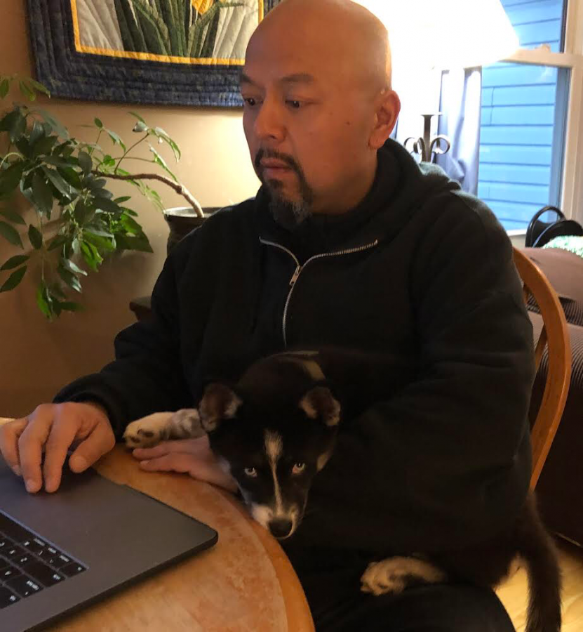 You can typically find Practitioner in Residence of Art Ron Alabanzas Pomsky, named Dakota, on his lap while he works from home.