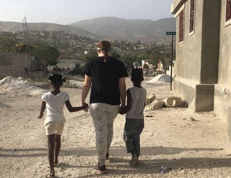 Junior Emily Wylie in Haiti holding the hands of children