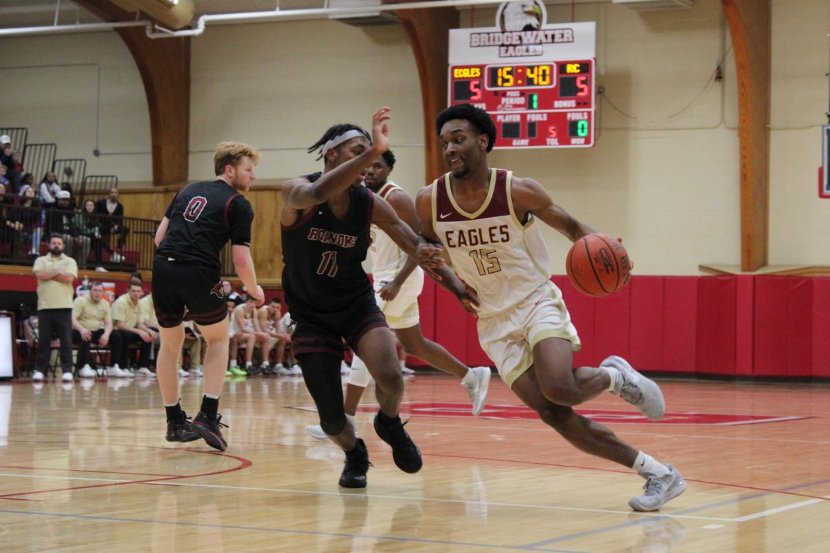 Junior Aaron Oates, number 15, intently dribbles down the court. The game was heated right from the beginning as Roanoke was tied with the Eagles.