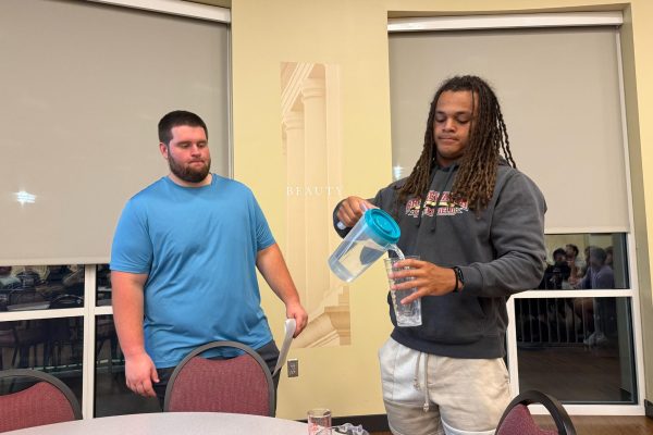 Senior Collin Nicholson (left) has volunteer junior Kyle Galloway (right) demonstrate how much a shot of liquor is. It is important for students to acknowledge what a standard shot of liquor looks like. 
 