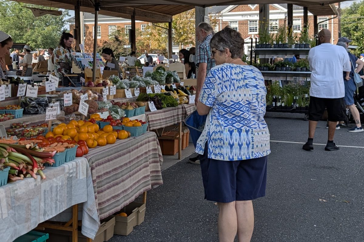  A woman pauses in front of fresh produce at a stand at Harrisonburg Farmers Market. Fresh produce plays a part in the market’s mission of assisting with environmental sustainability