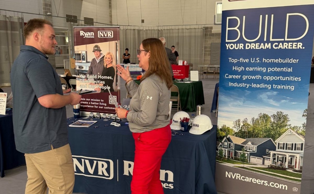 Senior Cam Martindale speaks with an employer at Alumni Connections and Career Fair. Students had the chance to network, ask questions and explore potential career paths. 