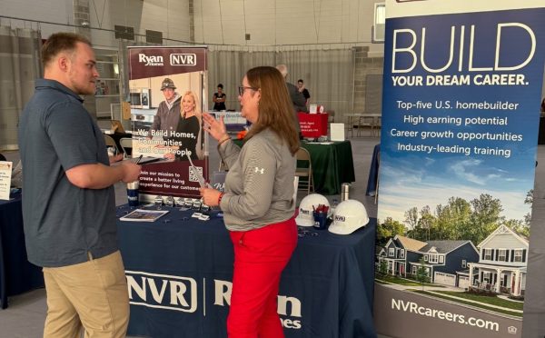 Senior Cam Martindale speaks with an employer at Alumni Connections and Career Fair. Students had the chance to network, ask questions and explore potential career paths. 