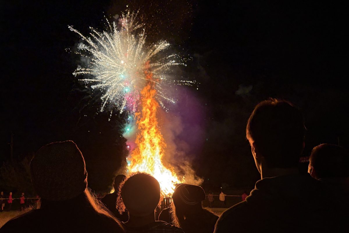 Onlookers stand in front of the bonfire, watching fireworks on the Dillon Lawn. Bonfire and Fireworks is a yearly part of Bridgewater’s Homecoming traditions.