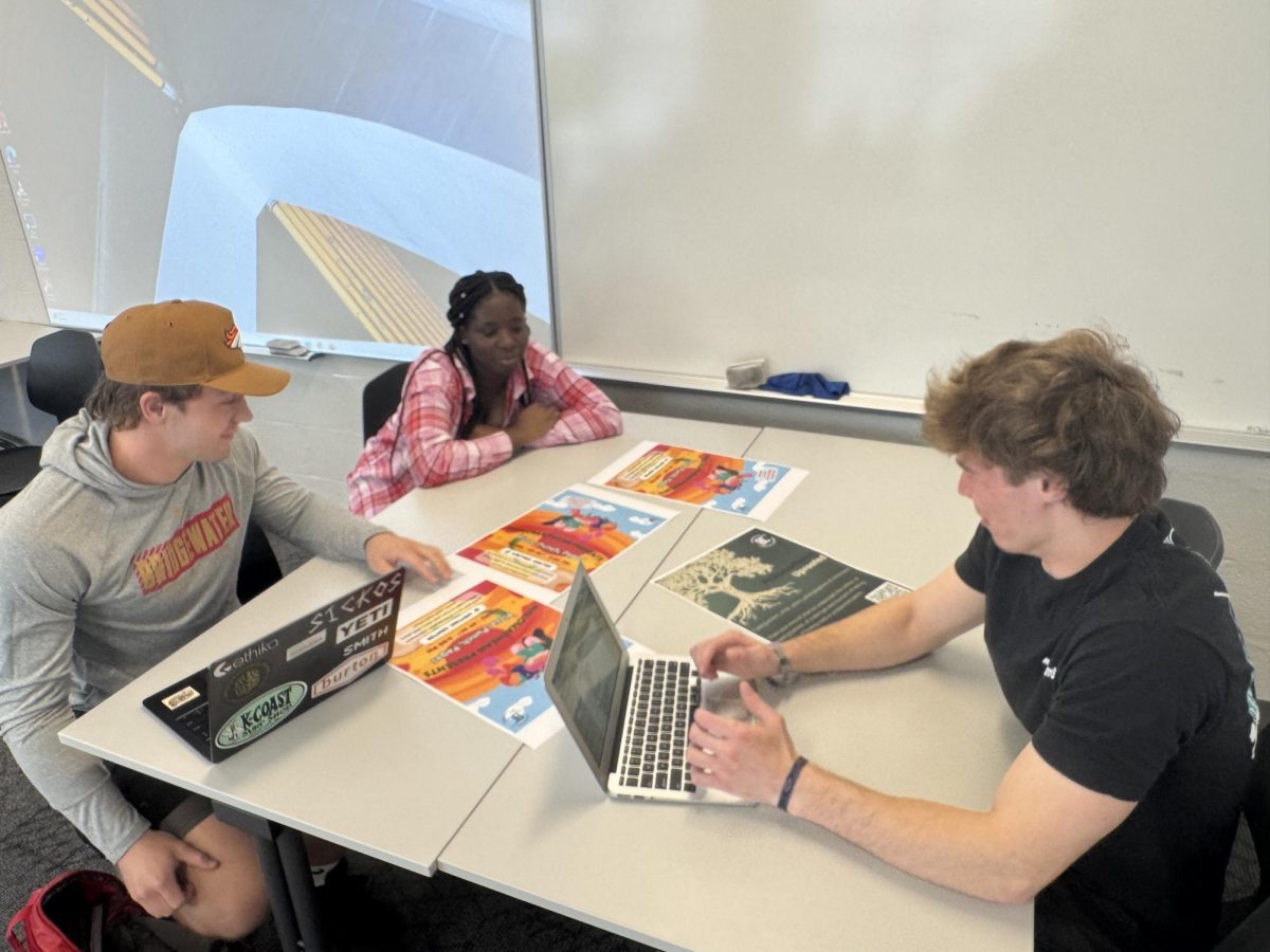 Tevyn Sowers (right), Wyatt Jervis (front left) and Philipa Effah (back left) organize flyers to share the Philomathean around campus. These flyers are to be passed out and hung up around Bridgewater's campus. 