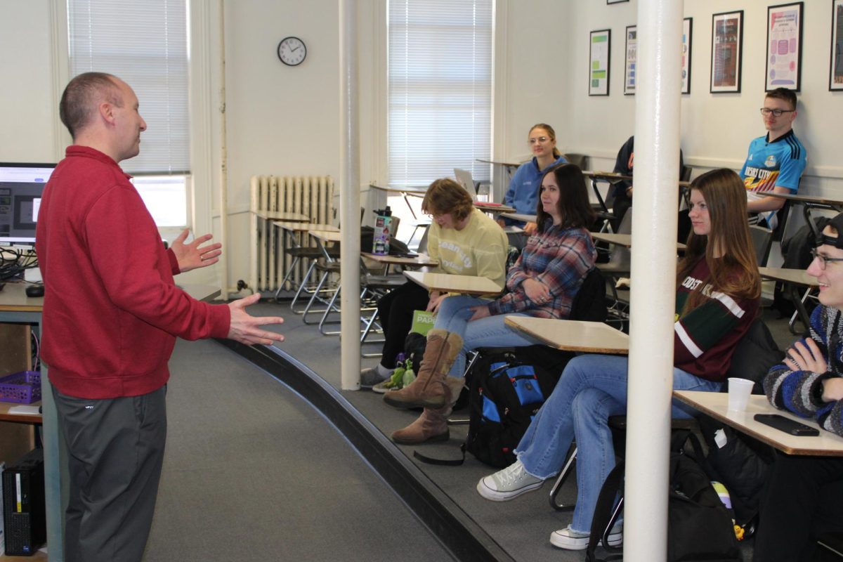 Professor Ben Erickson enthusiastically talking with students. It is an image that captures his energetic hand gestures.