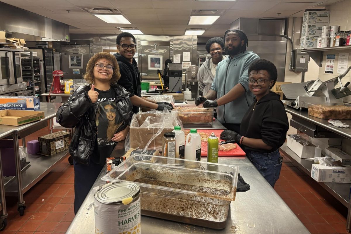 Members of the Black Student Alliance help prepare food in the dining hall kitchen ahead of the Jamaican-themed takeover on Feb. 10. BSA leaders worked alongside dining staff to assist with food preparation. Photo provided by BSA.