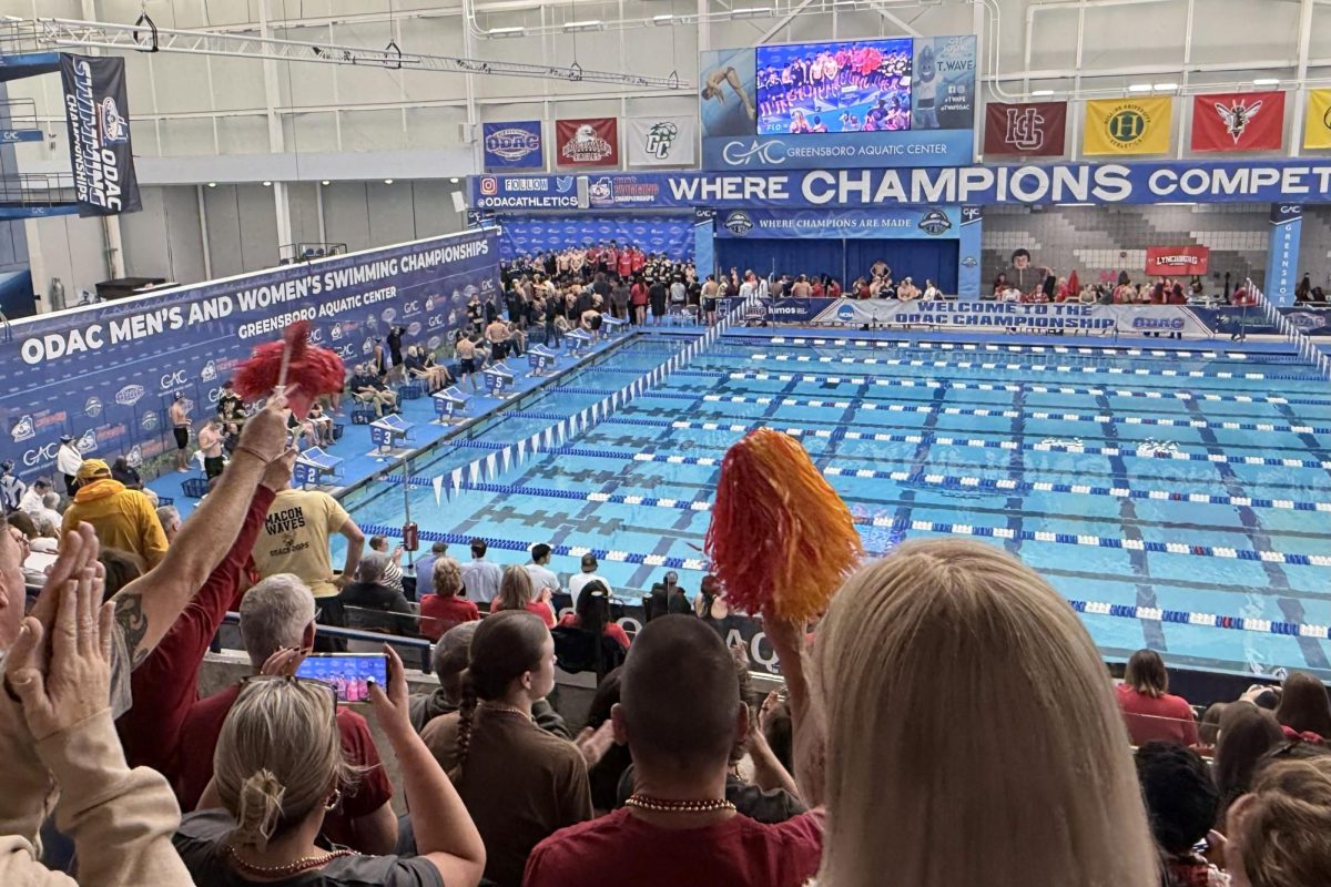 Bridgewater parents cheer from the stands in the Greensboro Aquatic Complex. Parents celebrated swimmers’ races over the four-day conference meet.