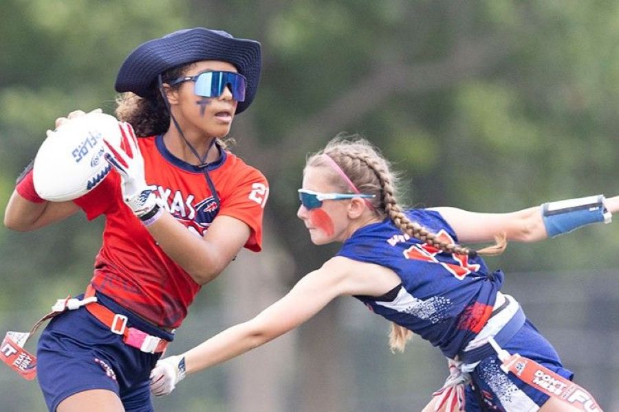 A Texas quarterback avoids the defense while looking downfield in a women’s flag football game. The play highlights the growth of flag football as a women’s sport at the high school and collegiate level. Image via iFlag. 